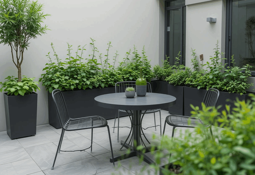 Modern balcony herb garden with basil and mint in black pots beside a sleek outdoor dining area.